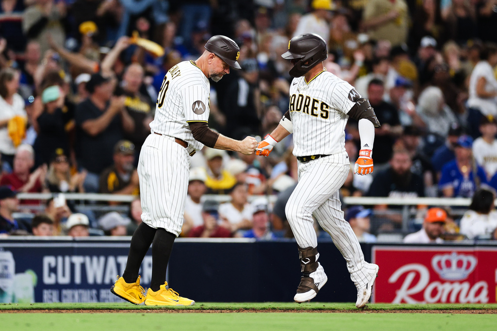 San Diego Padres' Ty France, right, is congratulated by third base coach Bob Henley, left, as he rounds the bag after hitting a solo home run against the Toronto Blue Jays in the sixth inning of a baseball game Saturday, July 11, 2026, in San Diego. (AP Photo/Derrick Tuskan)