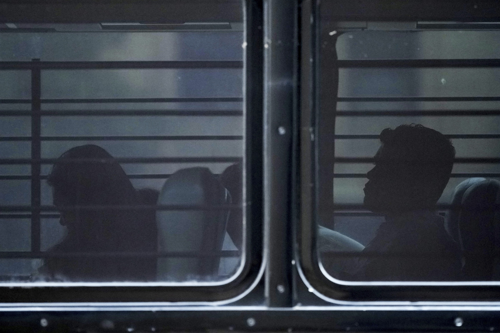 FILE - A family from Colombia sits on a bus with tinted and barred windows after they were detained by federal agents following an appearance at immigration court Monday, July 14, 2025, in San Antonio. (AP Photo/Eric Gay, File)
