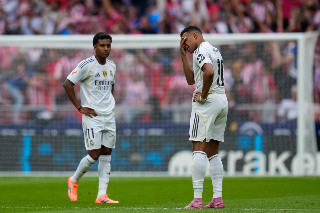Real Madrid's Kylian Mbappe, right, and Rodrygo stand after Atletico Madrid's Antoine Griezmann scored his side's fifth goal during the Spanish La Liga soccer match between Atletico Madrid and Real Madrid at Metropolitano stadium, in Madrid, Spain, Saturday, Sept. 27, 2025. (AP Photo/Manu Fernandez)