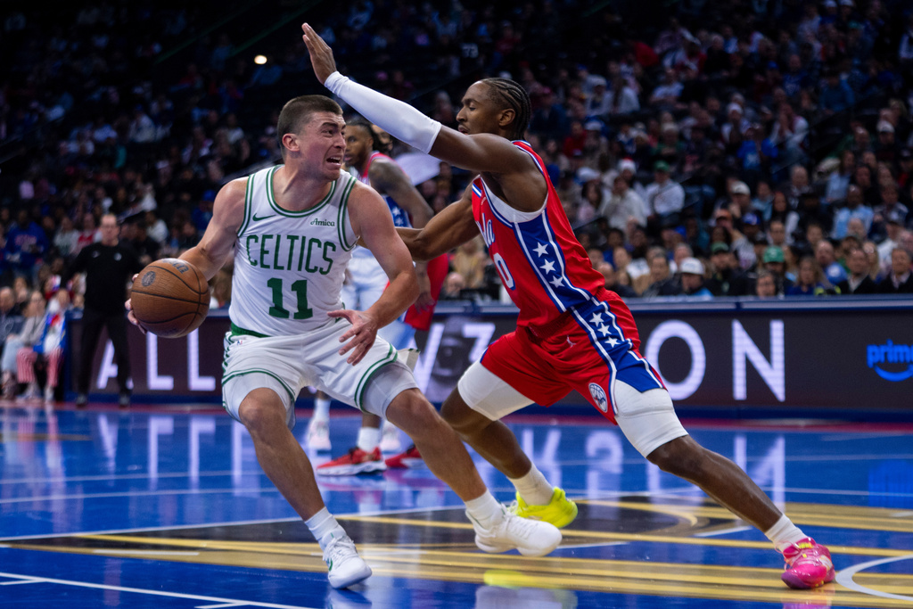 Boston Celtics' Payton Pritchard, left, drives to the basket against Philadelphia 76ers' Tyrese Maxey, right, during the first half of an NBA Cup basketball game, Friday, Oct. 31, 2025, in Philadelphia. (AP Photo/Chris Szagola)
