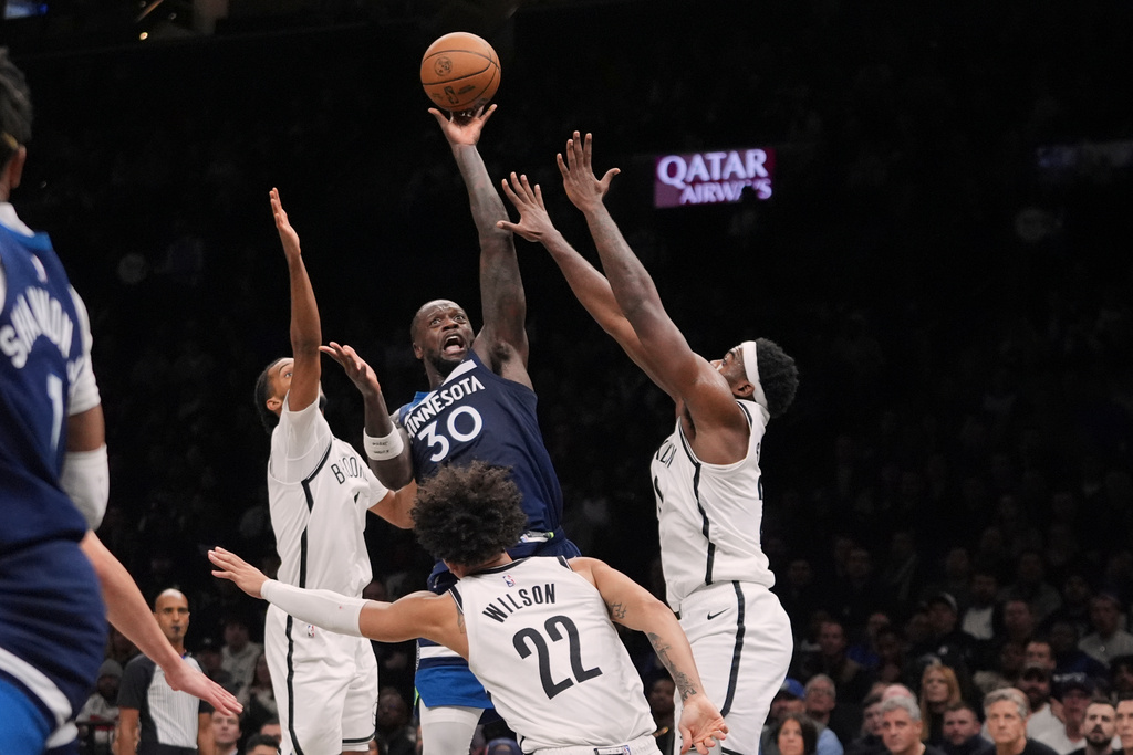 Minnesota Timberwolves' Julius Randle, center, shoots over Brooklyn Nets' Ziaire Williams, left, Day'Ron Sharpe, right, and Jalen Wilson, below during the second half of an NBA basketball game Monday, Nov. 3, 2025, at Barclays Center in New York. (AP Photo/Frank Franklin II)