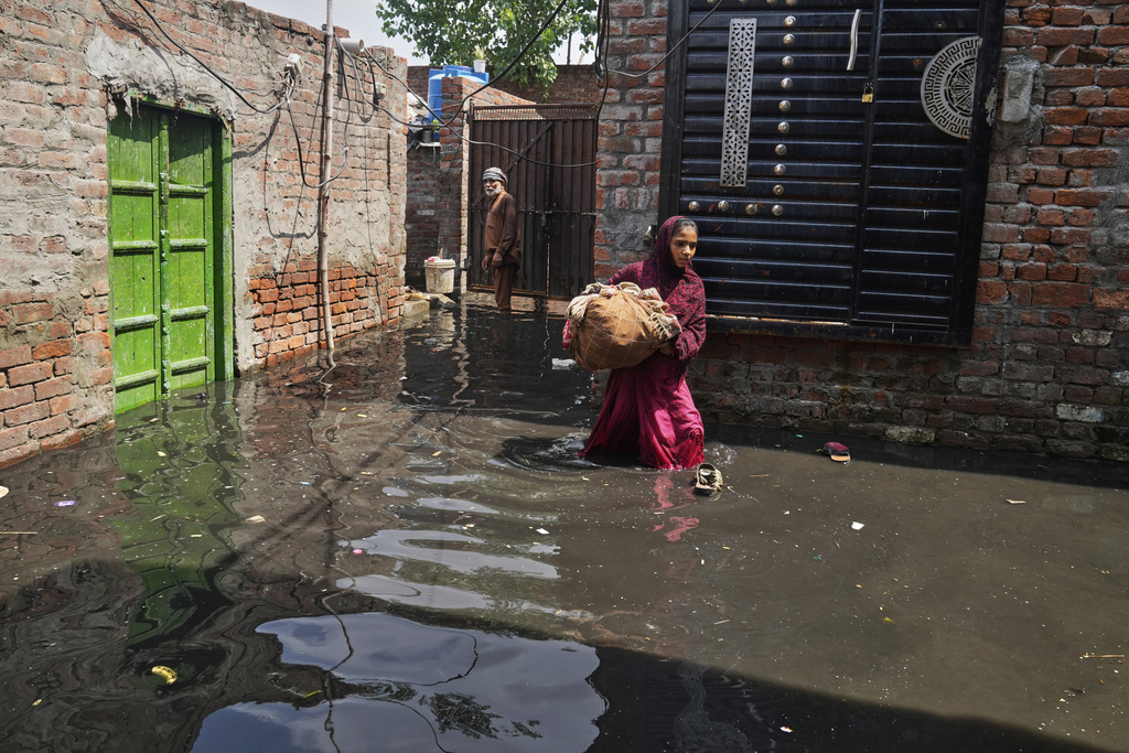 Residents retrieve belongings from their flooded home due to rising water level in Ravi River after torrential rains at a low-lying area on the outskirts of Lahore, Pakistan, Aug. 28, 2025. (AP Photo/K.M. Chaudary)