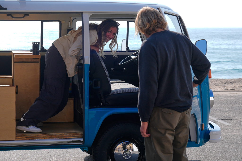 Megan Krystle Weinraub, left, and Preston Martin, who is the former owner, look over her Volkswagen bus as they see it for the first time Monday, Oct. 27, 2025, in Malibu, Calif., after it was restored by VW. (AP Photo/Mark J. Terrill)