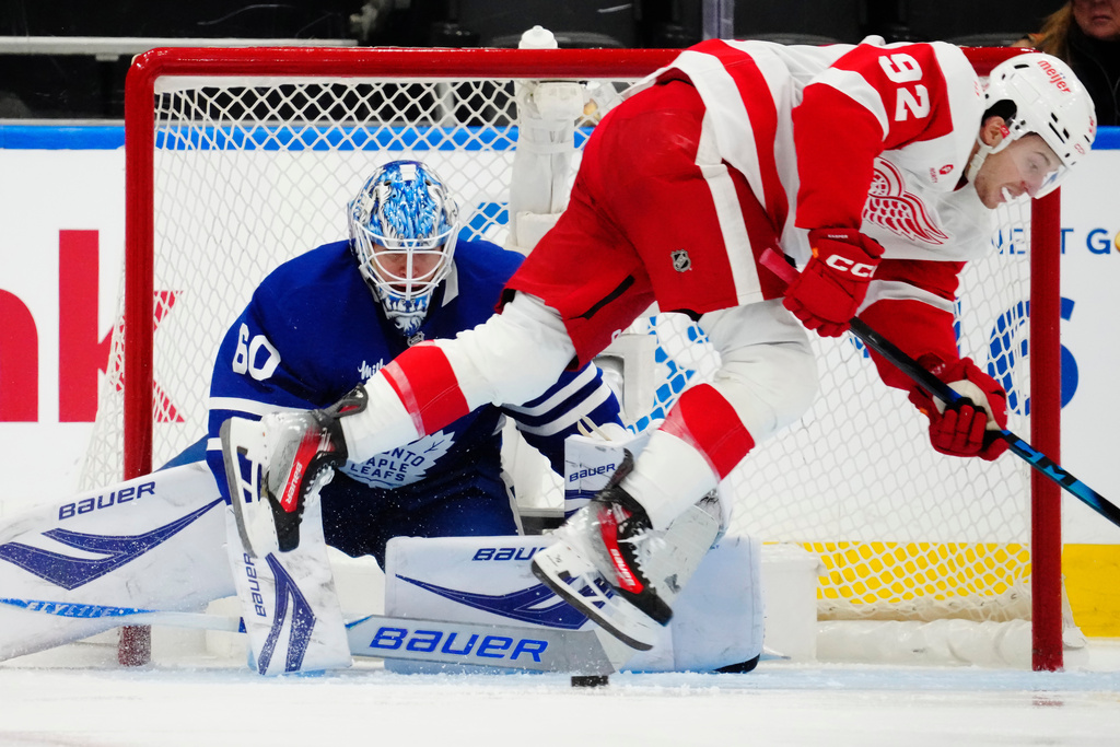 Toronto Maple Leafs goaltender Joseph Woll (60) makes a save as Detroit Red Wings' Marco Kasper (92) stumbles during second period NHL hockey action in Toronto on Wednesday, Jan. 21, 2026. (Frank Gunn/The Canadian Press via AP)