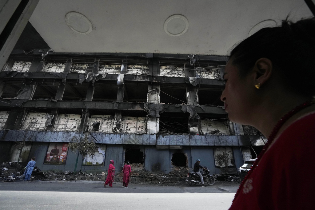 Nepalese people inspect a building of Bhatbhatini shopping center vandalized during anti-corruption protests protests sparked by a short-lived social media ban in Kathmandu, Nepal, Saturday, Sept. 13, 2025. (AP Photo/Niranjan Shrestha)