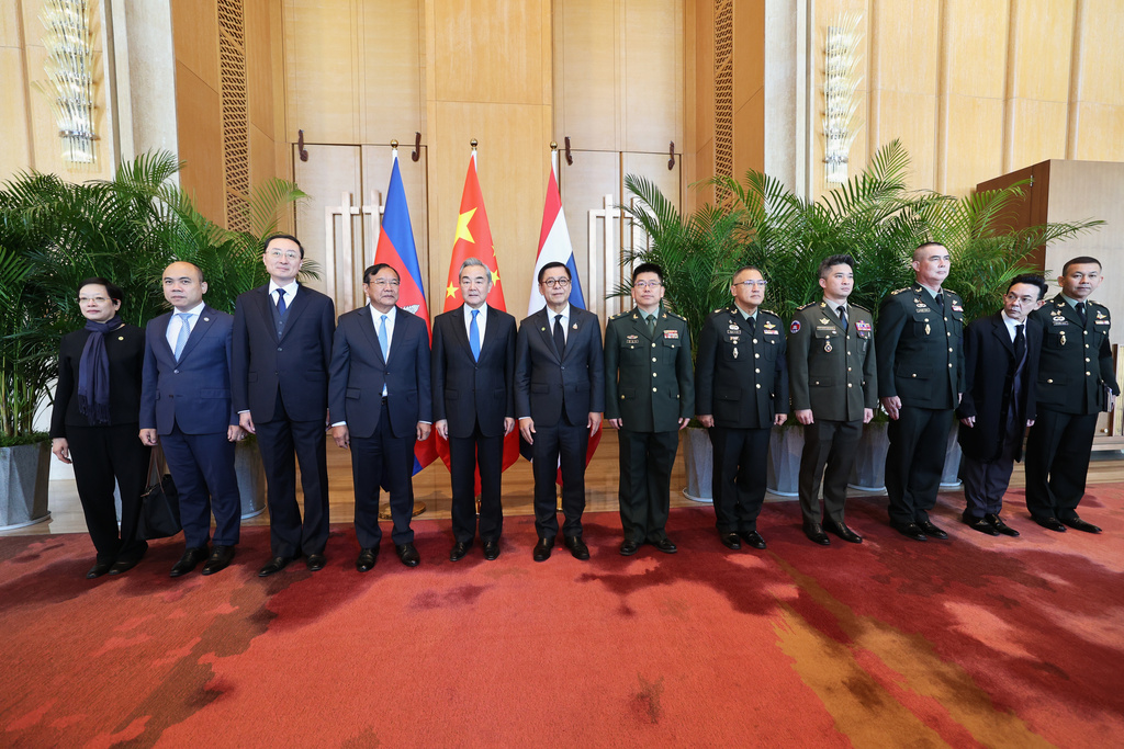 In this photo released by Agence Kampuchea Press (AKP), Cambodia's Foreign Minister Prak Sokhonn, fourth from left, poses for photographs together with his counterparts, China's Wang Yi, fifth from left, and Thailand's Sihasak Phuangketkeow, sixth from left, as accompanied by meeting delegation members in Yunnan province of China, Monday, Dec. 29, 2025. (AKP via AP)