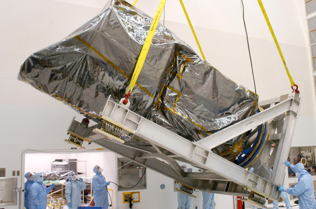 This photo provided by NASA shows an overhead crane raising the Swift spacecraft, wrapped in a protective cover, to vertical before being placed on a work standInside at Hangar AE at Cape Canaveral Air Force Station, in Florida on Sept. 9, 2002. (NASA via AP)