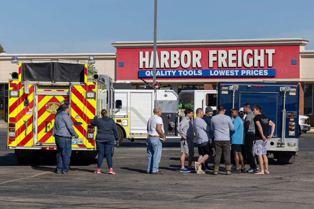 Business owners and first responders gather in a shopping center parking lot near the scene of an ammonia spill in Weatherford, Okla. after the shelter in place was lifted on Thursday, Nov. 13, 2025. (AP Photo/Alonzo Adams)