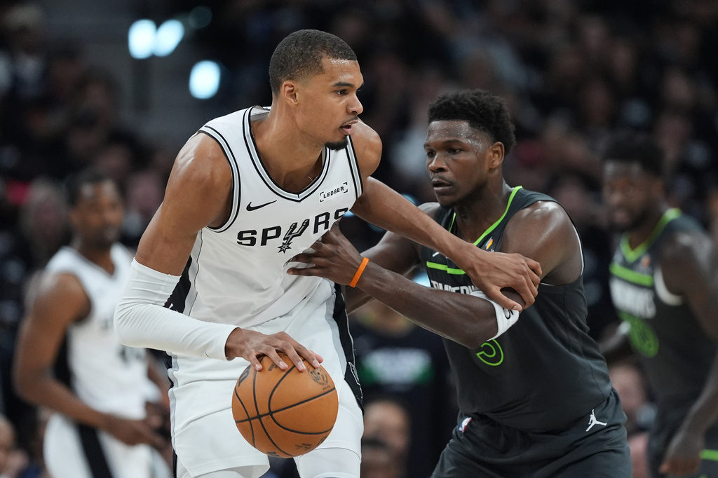 San Antonio Spurs forward Victor Wembanyama (1) drives against Minnesota Timberwolves guard Anthony Edwards (5) during the first half in Game 2 of a second-round NBA playoffs basketball series in San Antonio, Wednesday, May 6, 2026. (AP Photo/Eric Gay)