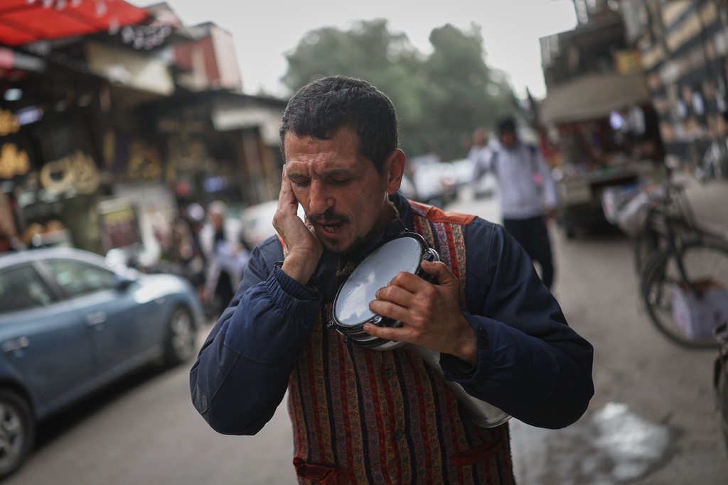 A man sings traditional Ramadan chants as residents prepare for the upcoming Muslim holy month of Ramadan at the Al-Jazmatiya market in Damascus, Tuesday, Feb. 17, 2026. (AP Photo/Ghaith Alsayed)