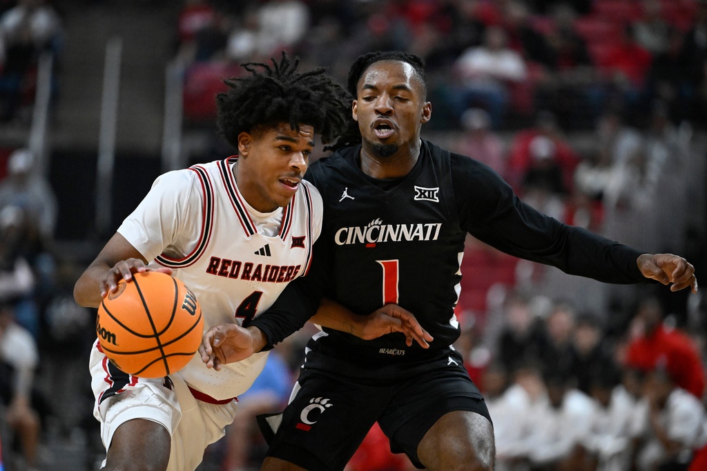 Texas Tech guard Christian Anderson (4) brings the ball up court against Cincinnati guard Day Day Thomas (1) during the first half of an NCAA college basketball game Tuesday, Feb. 24, 2026, in Lubbock, Texas. (AP Photo/Justin Rex)