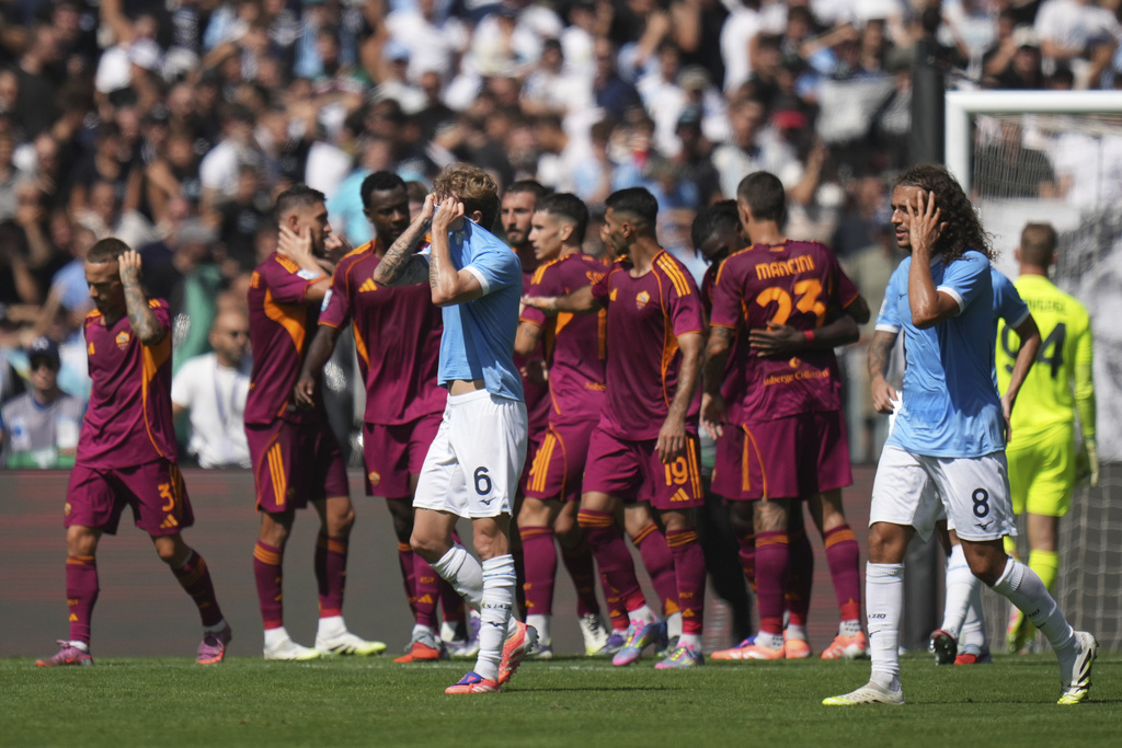 Lazio's Nicolo Rovella, centre, and Lazio's Matteo Guendouzi, right, react after Roma's Lorenzo Pellegrini scored during an Italian Serie A soccer match between Lazio and Roma, at the Olimpic Stadium, in Rome, Italy, Sunday, Sept. 21, 2025. (AP Photo/Alessandra Tarantino)