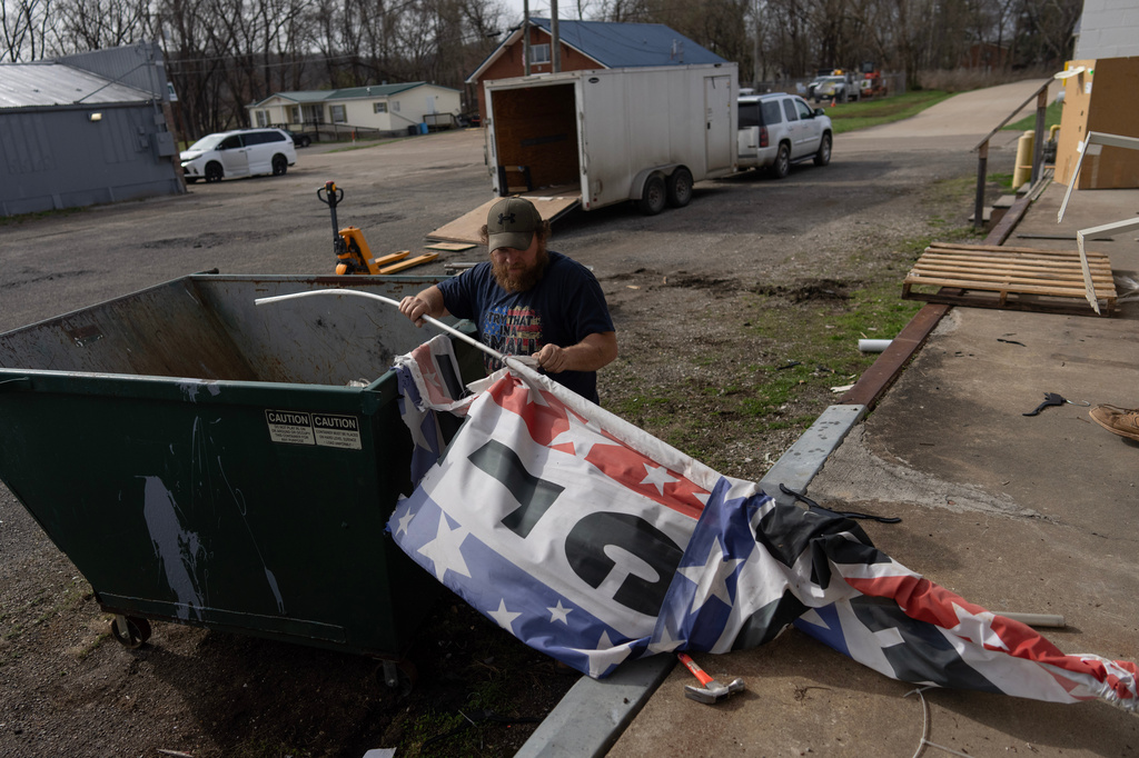 David Horne removes the "Welcome" banner from its pole to put in the dumpster as he works to close up one of the two JCD Bargain and Trade stores, which will consolidate into one location in Ravenswood, W.Va., Friday, March 13, 2026. (AP Photo/Carolyn Kaster)
