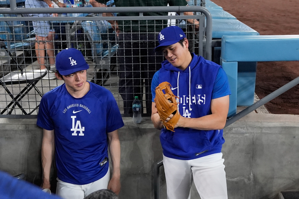 Los Angeles Dodgers' Roki Sasaki, left, and Shohei Ohtani chat in the dugout during a baseball game against the Cincinnati Reds, Wednesday, Sept. 9, 2026, in Los Angeles. (AP Photo/Mark J. Terrill)