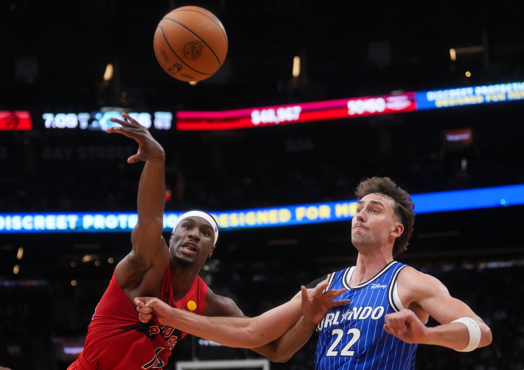 Toronto Raptors' Ja'kobe Walter (14) battles for the ball against Orlando Magic's Franz Wagner (22) during the second half of an NBA basketball game in Toronto, Wednesday, Oct. 28, 2026. (Nathan Denette/The Canadian Press via AP)