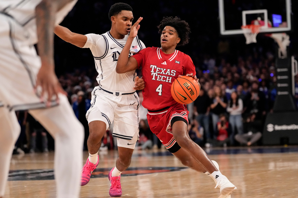 Texas Tech guard Christian Anderson (4) drives past Duke guard Caleb Foster (1) during the second half of an NCAA college basketball game, Saturday, Dec. 20, 2025, in New York. (AP Photo/Yuki Iwamura)