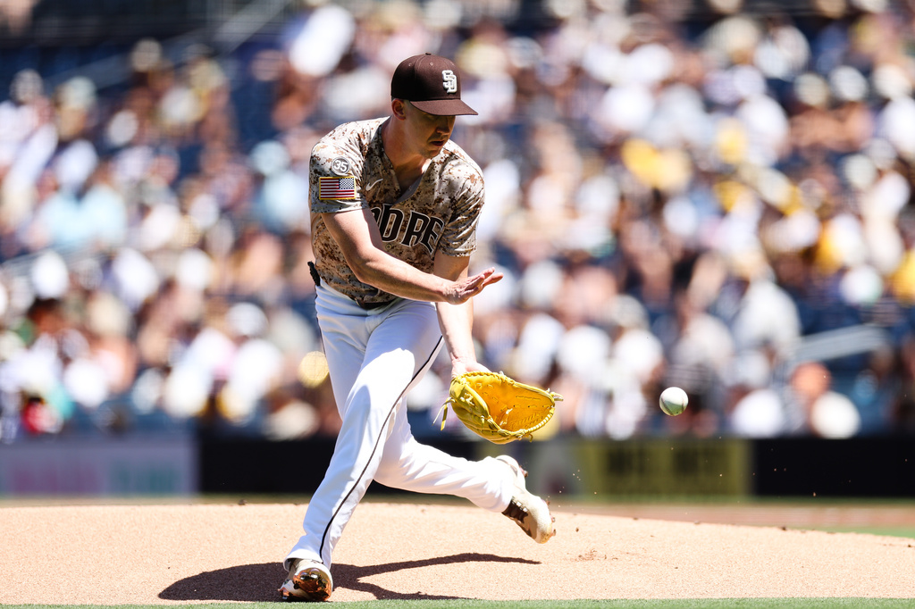 San Diego Padres pitcher Walker Buehler fields a ground ball hit by Minnesota Twins' Josh Bell in the first inning of a baseball game Sunday, Aug. 23, 2026, in San Diego. (AP Photo/Derrick Tuskan)