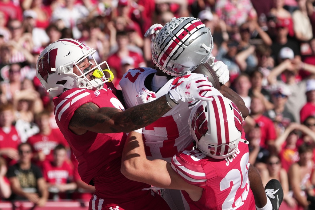 Ohio State's Carnell Tate catches a touchdown pass in front of Wisconsin's Austin Brown and Matt Jung during the first half of an NCAA college football game Saturday, Oct. 18, 2025, in Madison, Wis. (AP Photo/Morry Gash)