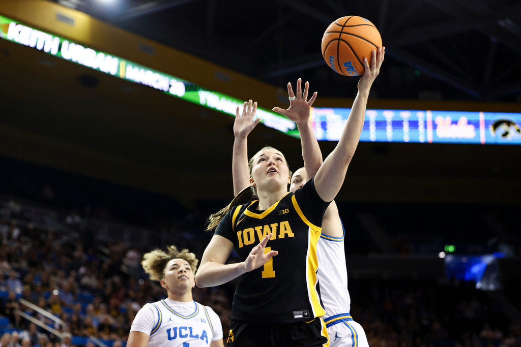 Iowa guard Taylor Stremlow (1) drives to the basket against UCLA forward Angela Dugalić, back right, as UCLA guard Kiki Rice, left, watches during the first half of an NCAA college basketball game, Sunday, Feb. 1, 2026, in Los Angeles. (AP Photo/Jessie Alcheh)