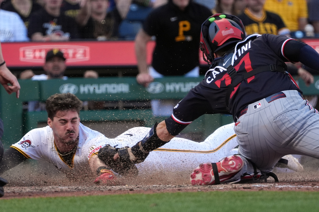 Pittsburgh Pirates' Konnor Griffin, left, slides around a tag by Minnesota Twins catcher Victor Caratini, right, to score on a single by Jake Mangum in the fifth inning of a baseball game in Pittsburgh, Saturday, May 30, 2026. (AP Photo/Tom E. Puskar)