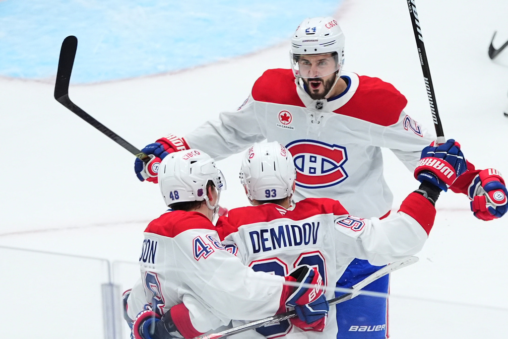Montréal Canadiens defenseman Lane Hutson (48) celebrates after his overtime goal with right wing Ivan Demidov (93) and center Phillip Danault (24) during an NHL hockey game against the Dallas Stars, Sunday, Jan. 4, 2026, in Dallas. (AP Photo/LM Otero)