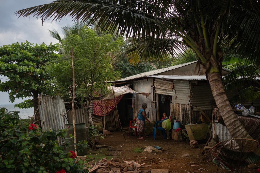 Family members appear at their home near the sea in the community of Zapotitlan, Mexico, Oct. 26, 2025. (AP Photo/Felix Marquez)