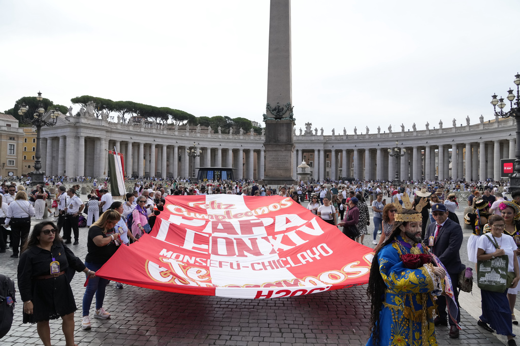 Faithful from Peru display a banner wishing happy 70th birthday to Pope Leo XIV with a statue of Jesus Nazareno Cautivo de Monsefu, as he appears at his studio's window to bless the faithful gathered in St. Peter's Square at the Vatican for the Angelus prayer, Sunday, Sept. 14, 2025. (AP Photo/Gregorio Borgia)