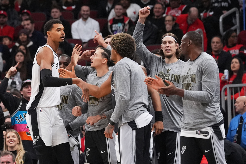 San Antonio Spurs forward Victor Wembanyama, left, celebrates with teammates after scoring a basket during the first half of an NBA basketball game against the Chicago Bulls in Chicago, Monday, Nov. 10, 2025. (AP Photo/Nam Y. Huh)