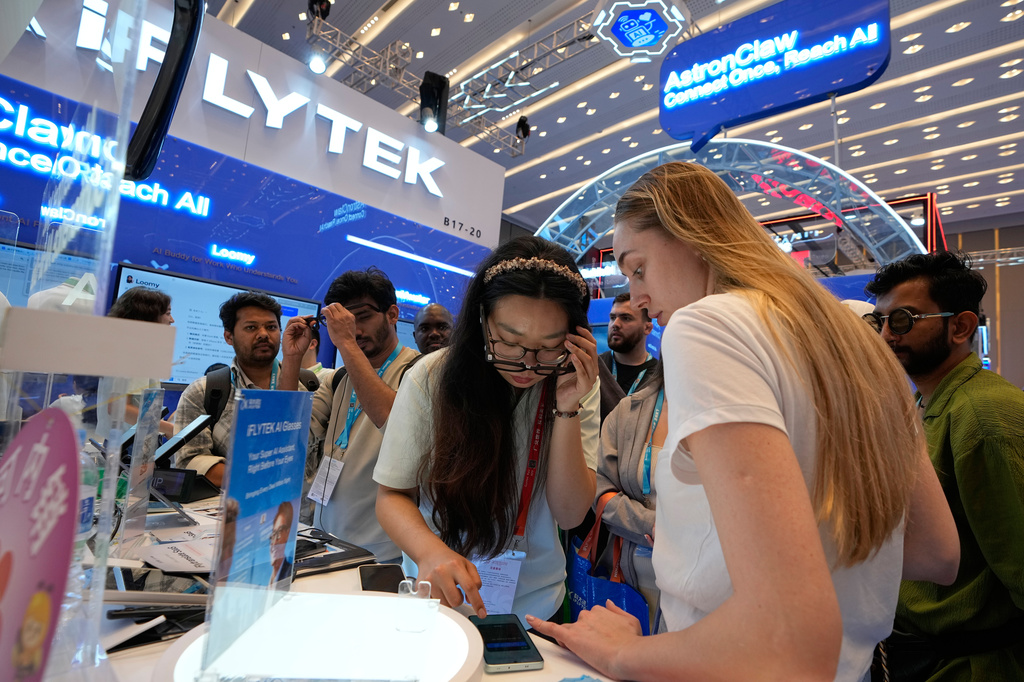 Foreign visitors try out the AI-powered glasses by iFLYTEK at the Canton Fair, in Guangzhou, in southern China's Guangdong province, Wednesday, April 15, 2026. (AP Photo/Andy Wong)