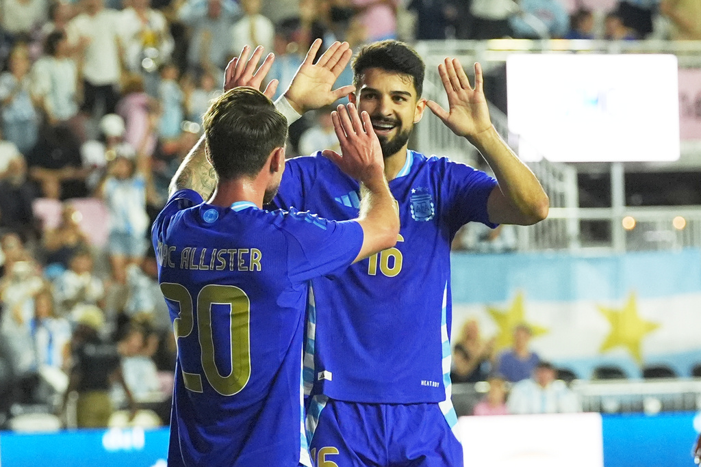 Argentina's Alexis Mac Allister (20) celebrates his goal with Flaco Lopez (16) during the first half of a friendly soccer match against Puerto Rico, Tuesday, Oct. 14, 2025, in Fort Lauderdale, Fla. (AP Photo/Marta Lavandier)