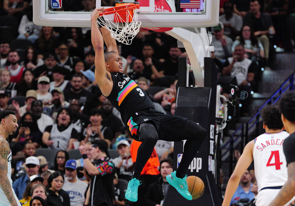 San Antonio Spurs forward Keldon Johnson, center, dunks during the first half of an NBA basketball game against the Los Angeles Clippers, Friday, March 6, 2026, in San Antonio. (AP Photo/Darren Abate)
