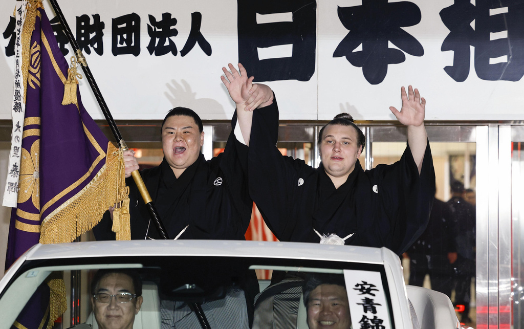 Ukrainian Aonishiki, right, waves during a parade after winning the Kyushu Grand Sumo Tournament in Fukuoka, western Japan, Sunday, Nov. 23, 2025. (Kyodo News via AP)
