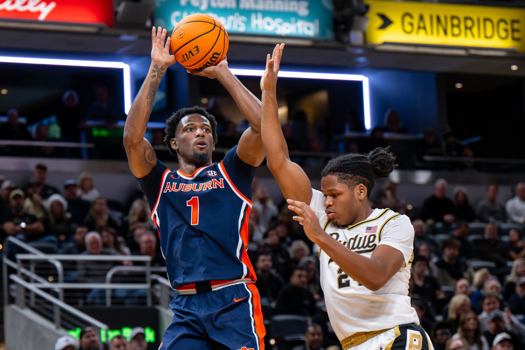 Auburn guard Kevin Overton (1) looks to shoot while being defended by Purdue guard Gicarri Harris, right, during the second half of an NCAA college basketball game, Saturday, Dec. 20, 2025, in Indianapolis (AP Photo/Doug McSchooler)