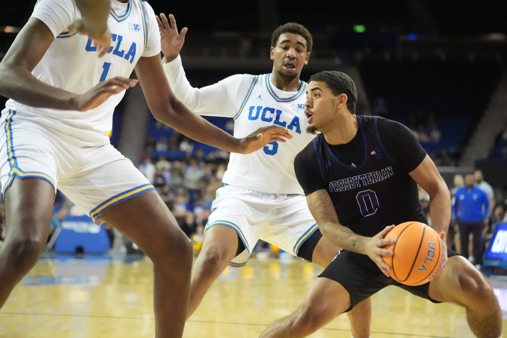 Presbyterian guard Iverson King (0) dribbles against UCLA guard Brandon Williams (5) during the first half of an NCAA college basketball game in Los Angeles, Friday, Nov. 21, 2025. (AP Photo/Damian Dovarganes)