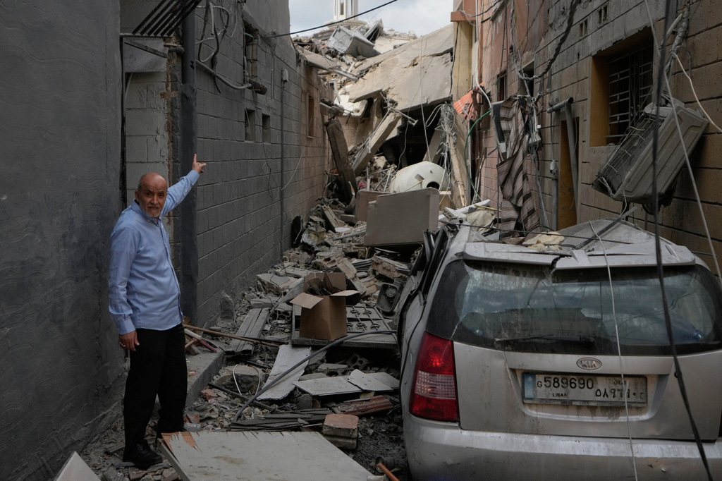 A man points into a destroyed building that was hit in an Israeli airstrike in Burj al-Shemali village near the southern port city of Tyre, Lebanon, Tuesday, May 26, 2026. (AP Photo/Mohammed Zaatari)