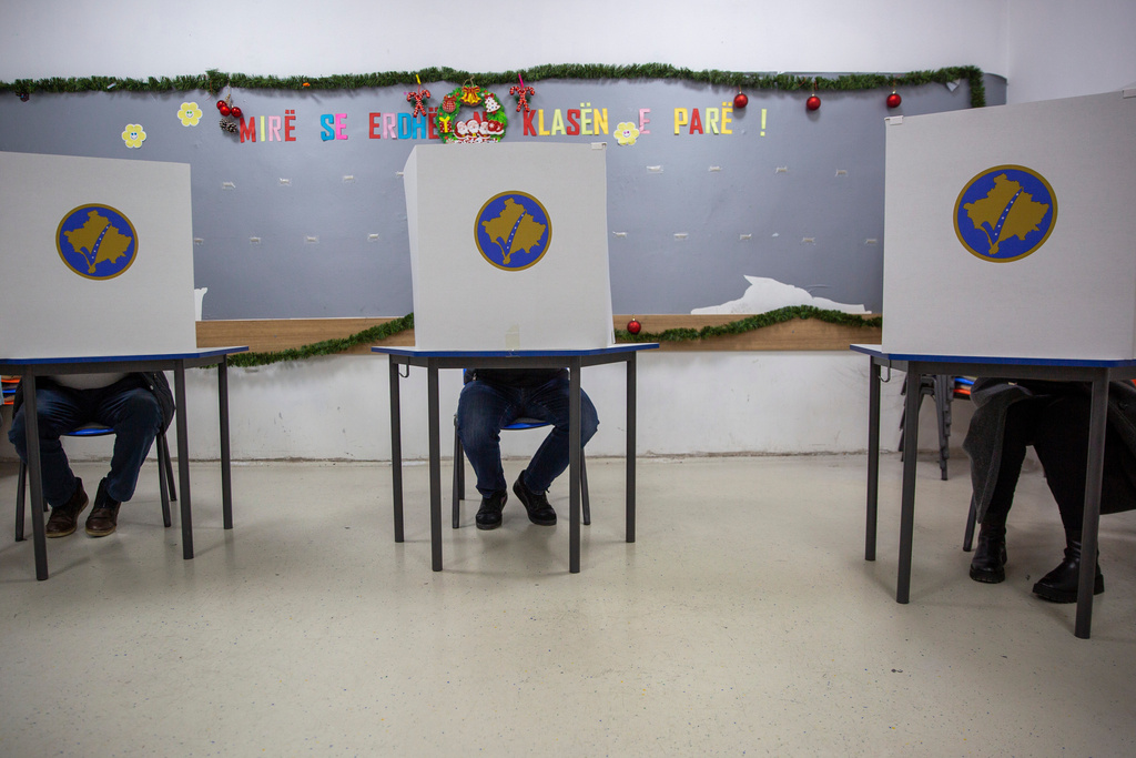 Voters fill their ballots behind voting booths for early parliamentary election in Kosovo's capital Pristina, Sunday Dec. 28, 2025. (AP Photo/Visar Kryeziu)