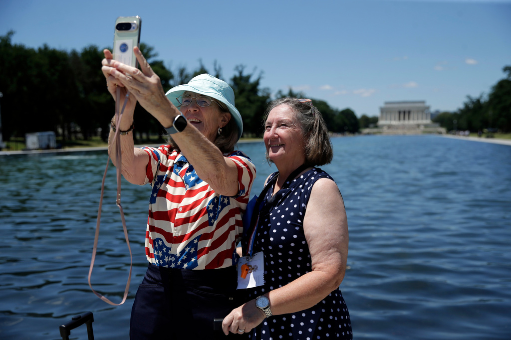 Visitors take a selfie at the Lincoln Memorial Reflecting Pool, Wednesday, June 24, 2026, in Washington. (AP Photo/Rahmat Gul)