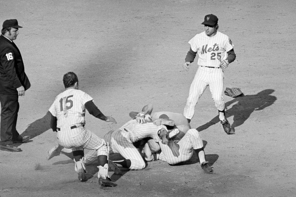FILE - Pete Rose of the Cincinnati Reds (14) and Bud Harrelson (3) of the New York Mets engage in a tussle after double play action during the fifth inning of the third National League playoff game in New York, Oct. 8, 1973. (AP Photo/Harry Harris, File)