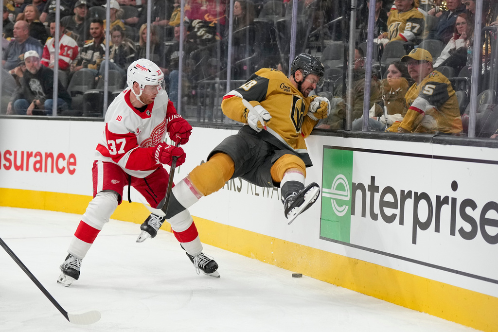 Vegas Golden Knights center Tomas Hertl (48) hits the boards near Detroit Red Wings left wing J.T. Compher (37) in the second period of an NHL hockey game Tuesday, Nov. 4, 2025, in Las Vegas. (AP Photo/Candice Ward)