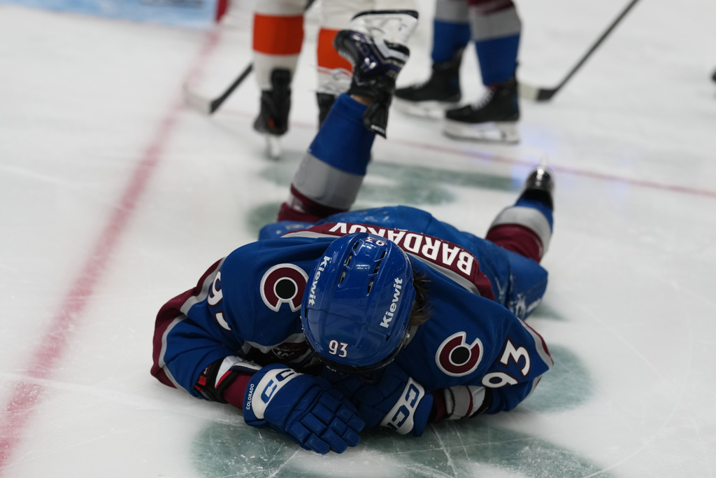 Colorado Avalanche center Zakhar Bardakov lies on the ice after being injured when he ran into the end boards in the third period of an NHL hockey game against the Philadelphia Flyers, Friday, Jan. 23, 2026, in Denver. (AP Photo/David Zalubowski)