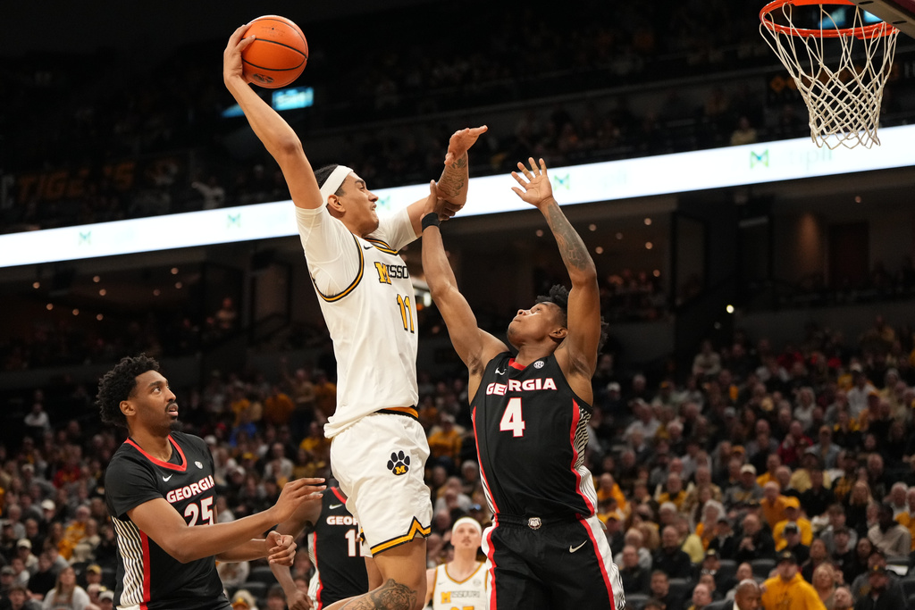 Missouri's Trent Pierce (11) heads to the basket as Georgia's Justin Abson (25) and Marcus Millender (4) defend during the second half of an NCAA college basketball game Tuesday, Jan. 20, 2026, in Columbia, Mo. (AP Photo/Jeff Roberson)