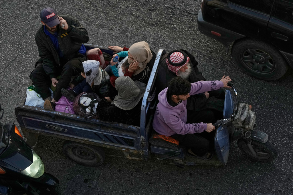 A family flees Israeli airstrikes in Dahiyeh, Beirut's southern suburbs, riding a three-wheeled motorized vehicle known as a "tok-tok," on a highway in Beirut, Lebanon, Thursday, March 5, 2026. (AP Photo/Bilal Hussein)