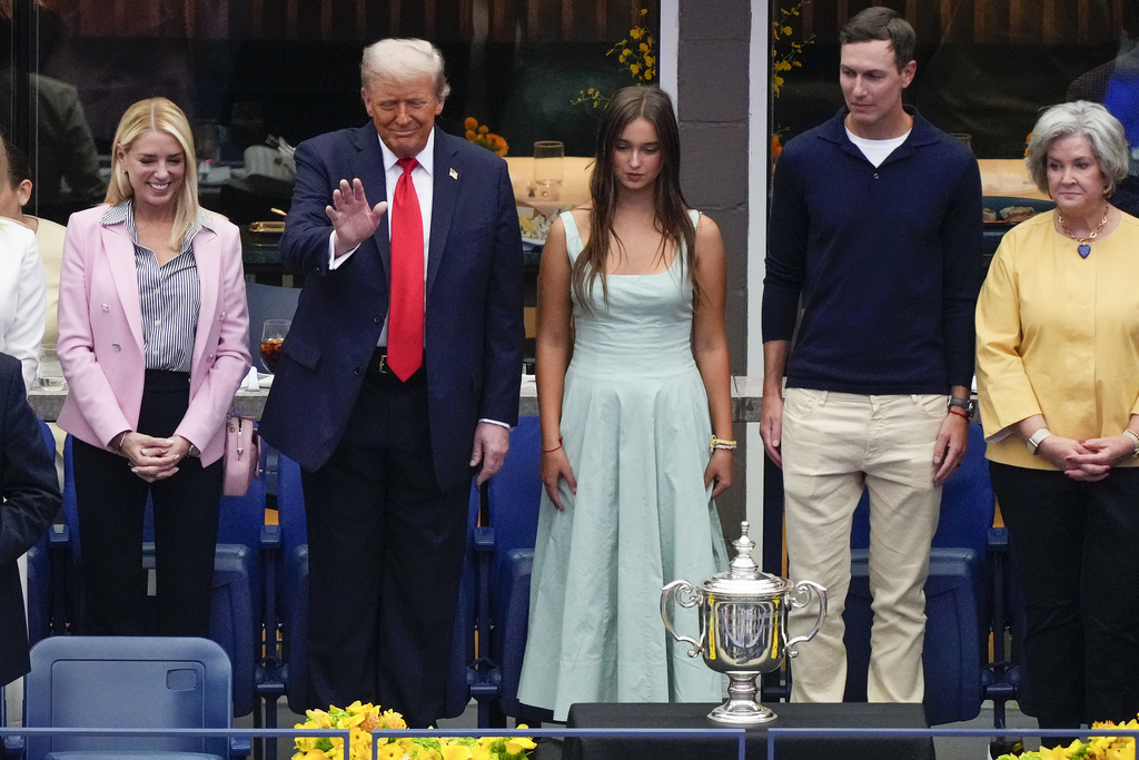 President Donald Trump waves to spectators while accompanied by U.S. Attorney General, Pam Bondi, left, Arabella Kushner third from left, Jared Kushner, second from right, and Susie Wiles, White House Chief of Staff, during the men's singles final of the U.S. Open tennis championships, Sunday, Sept. 7, 2025, in New York. (AP Photo/Yuki Iwamura)