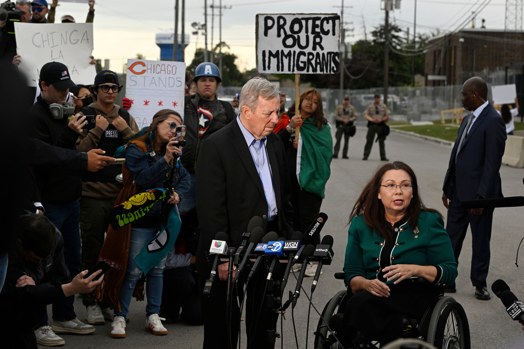 Sen. Tammy Duckworth, D-Ill., speaks to the media while Sen. Dick Durbin, D-Ill., listens outside the U.S. Immigration and Customs Enforcement facility in Broadview, Ill., Friday, Oct. 10, 2025. (AP Photo/Paul Beaty)