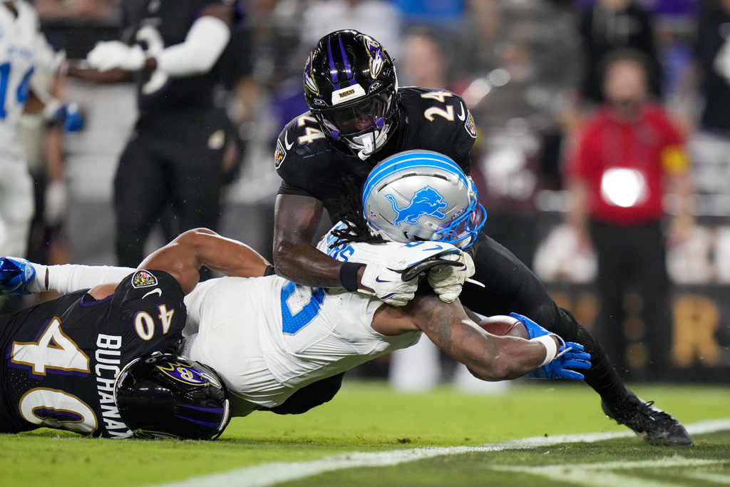 Detroit Lions running back Jahmyr Gibbs (0) tries to cross the goal line as Baltimore Ravens linebacker Teddye Buchanan (40) and safety Malaki Starks (24) try to stop him during the first half of an NFL football game Monday, Sept. 22, 2025, in Baltimore. (AP Photo/Stephanie Scarbrough)