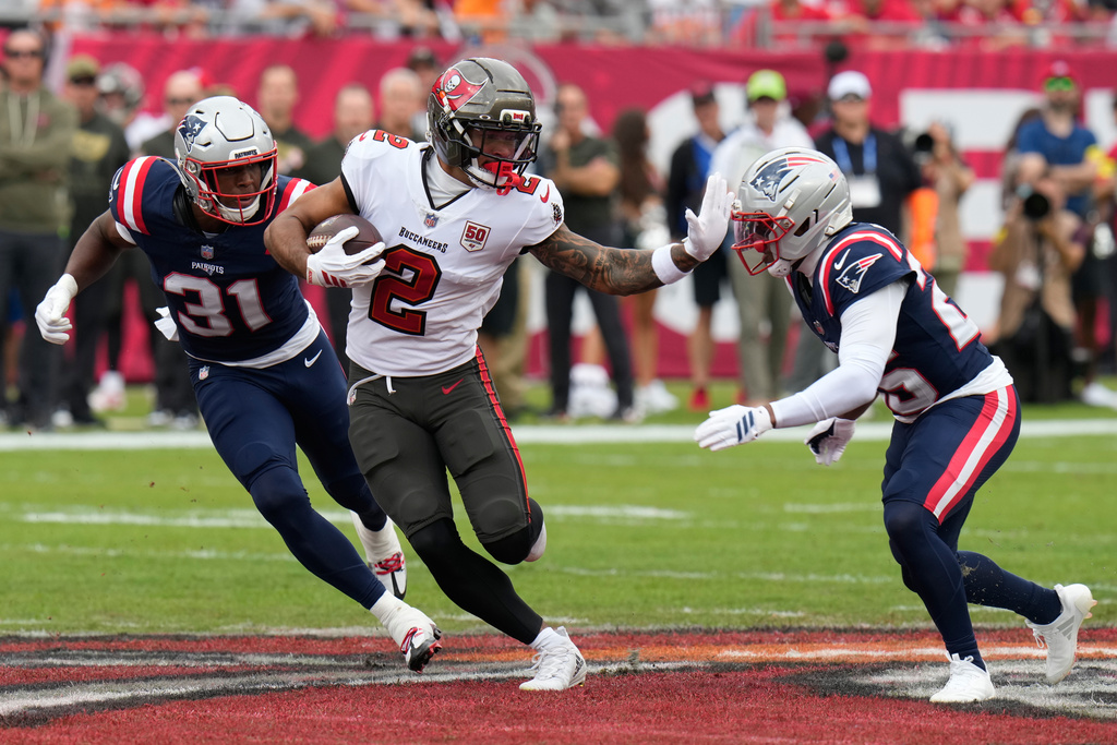 Tampa Bay Buccaneers wide receiver Emeka Egbuka (2) runs after a catch against New England Patriots cornerback Marcus Jones, right, during the first half of an NFL football game Sunday, Nov. 9, 2025, in Tampa, Fla. (AP Photo/Chris O'Meara)