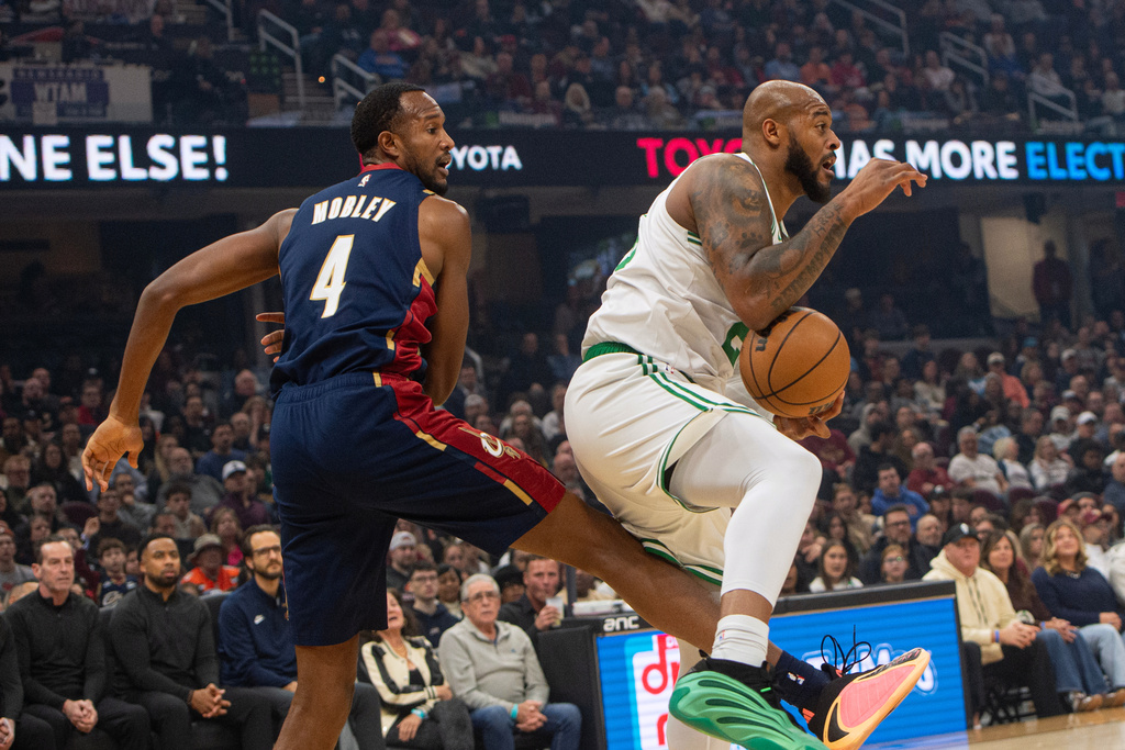 Boston Celtics' Xavier Tillman, left, secures a rebound in front of Cleveland Cavaliers' Evan Mobley during the first half of an NBA basketball game in Cleveland, Sunday, Nov. 30, 2025. (AP Photo/Phil Long)