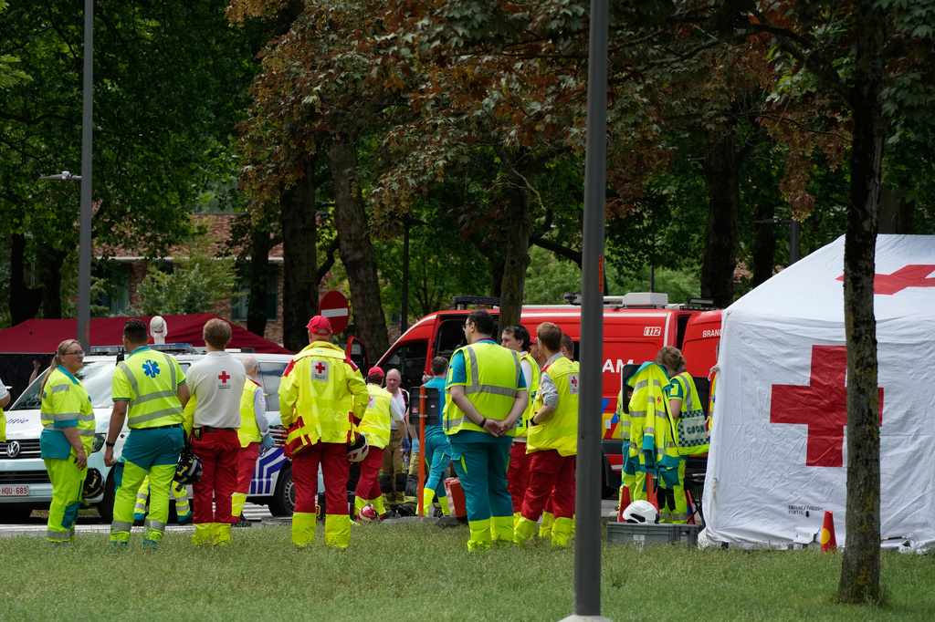 Rescue workers wait by a tent to receive injured after an apartment block fire in Linkeroever, Belgium, Wednesday, July 1, 2026. (AP Photo/Virginia Mayo)