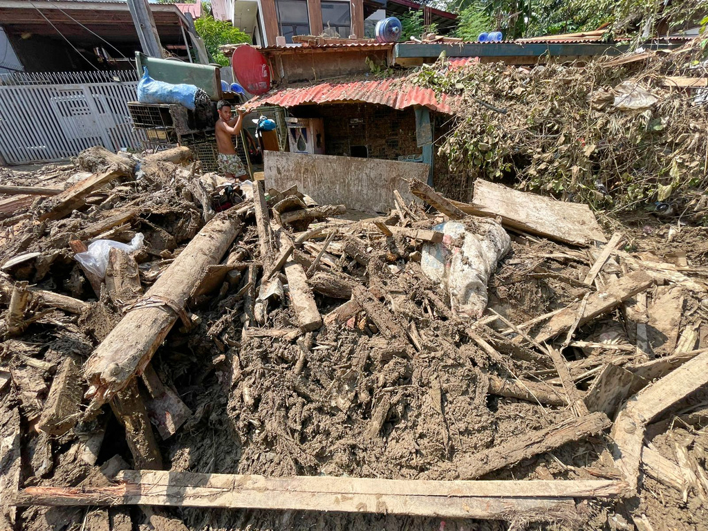Debris lays outside a house as residents return to their flood damaged homes in Bacayan, Cebu province, central Philippines on Friday Nov. 7, 2025 after Typhoon Kalmaegi devastated the province and claimed lives. (AP Photo/Jacqueline Hernandez)