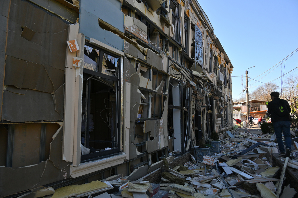 A person walks near residential houses damaged by a Russian strike in Odesa, Ukraine, Monday, April 27, 2026. (AP Photo/Michael Shtekel)